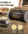 Person carrying rolled 2 Inch Memory Foam Comfy Camping Cot Pad For Folding Cots With Removable Cover Non Slip Waterproof Bottom