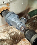 Close-up of Tank Cleaner Water Heater Tool for Quick Flush and Sediment Removal in use with drill and hose attachment.