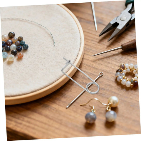 20pcs Stainless Steel Brooch Shape Cotter Pins Quick Lock Spring Safety Fasteners on a crafting workspace with beads.