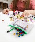 Child assembling blocks next to a 30 Pack Small Zipper Mesh Pouches With Label Pockets, A6 Size 6.3 By 4.7 Inches, in use for toys.