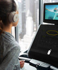 Person using Wireless Bluetooth Audio Transmitter For AirPods And Headphones With 20 Plus Hour Battery at gym treadmill.