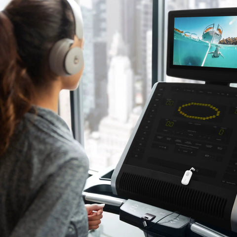 Person using Wireless Bluetooth Audio Transmitter For AirPods And Headphones With 20 Plus Hour Battery at gym treadmill.