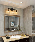 Three Light Black And Gold Bathroom Vanity Light Fixture With Metal Base And Clear Glass Globe Shades, Modern Over Mirror Bath Lighting That Elevates Your Space With Sleek Durable Build And High End Look in elegant bathroom setting.