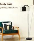 Industrial Floor Lamp With Adjustable Three Light Tree Stand shown next to a chair, highlighting its sturdy base.