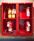 Bulk Fire Extinguisher Inspection Tags Kit With 200 Tags, 200 Adjustable Zip Ties, And 200 Monthly And Annual Safety Tags displayed on fire extinguishers in a red cabinet.