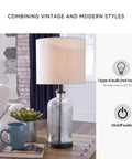 Modern Farmhouse Seeded Glass Table Lamp in Bronze Finish, 22.5 Inch Tall on a wooden table with books and a mug
