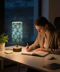 Watercolor Palm Leaf Blue Bedside Table Lamp With 3 Way Dimmable Touch Control And Built In Charging Station on desk at night