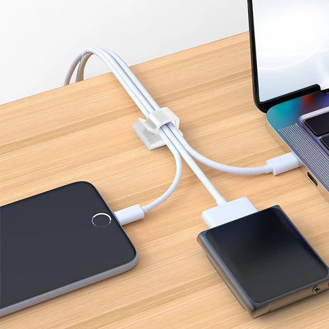 100 Pack Adhesive Cable Clips Clear for Cables Up To 5mm organizing wires on a wooden desk with a phone and laptop.