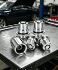 Beefy Anti Theft Wheel Lock Lug Nuts, M12 X 1.5 Chrome Plated Security Fasteners With Custom Cut Key, Four Piece Set displayed on a workbench.