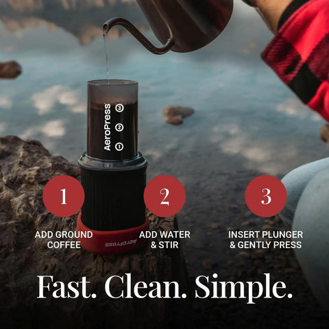 Ultra Portable Travel Coffee Maker Kit For Grab And Go Outdoors All In One French Press Pour Over And Espresso Style Manual Brewer For Camping And Hiking Two Minute Brew For A Less Bitter More Flavorful Cup, grey Aeropress in use outdoors, adding water.