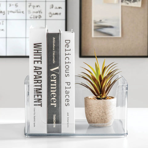 Stackable Open Front Kitchen Storage Bin With Handles Clear Plastic Organizer holding books and a small plant on a white surface