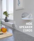 Modern kitchen counter with fruit, wall-mounted speaker, and text reading 'Hide Speaker Cords.'