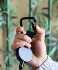 Hand holding Heavy Duty Retractable Keychain With Waist Hanging Design Expandable 60cm Wire Rope for camping and fishing
