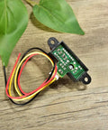 Sharp IR Analog Distance Sensor GP2Y0A21YK0F 10 To 80 Cm with exposed circuit and wires on wooden surface