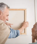 Elderly couple using All In One 276 Piece Picture Hanging Kit With Hangers And Hardware to mount frame on wall