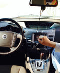 Wingbrake-V driver training brake in a car; interior view with steering wheel and a person adjusting controls.