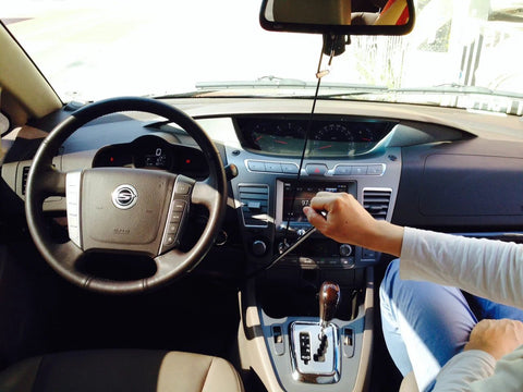 Wingbrake-V driver training brake in a car; interior view with steering wheel and a person adjusting controls.