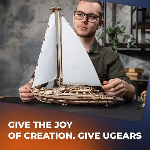 Serenity's Dream Model Yacht Kit Wind Up 3D Wooden Puzzle For Adults DIY Sailboat Model 17.3 Inch Tall Hands On Mechanical Boat Craft For Enthusiasts Great Gift, man holding assembled wooden sailboat