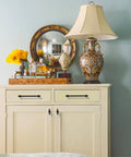 Room with a lamp, mirror, flowers, and a decorated cabinet with Oil Rubbed Bronze Cabinet Knobs Set, 10 Pack, 1 Inch 25mm For Cabinets And Drawers, Kitchen Cabinet Hardware And Dresser Knobs, Rust Proof Zinc Alloy With Matte Finish And Scratch Resistant CK0081 By Coinkoly