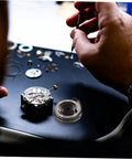 Hands repairing clock mechanism with Pro Grade Mechanical Alarm Clock Repair Kit With Precision Springs.