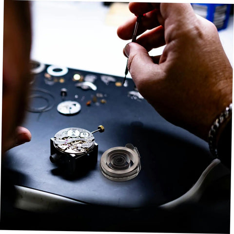 Hands repairing clock mechanism with Pro Grade Mechanical Alarm Clock Repair Kit With Precision Springs.