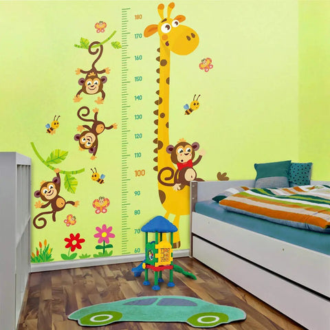 Giraffe And Monkeys Kids Height Wall Chart With Peel And Stick Nursery Wall Decals For Baby Bedroom And Toddler Playroom, Measures Up To 180 Cm, Colorful Removable Wall Stickers next to a bed and toys in a nursery room.