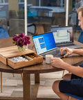 Acacia Wood Coffee Pod Drawer Organizer for K Cups and OriginalLine on table next to person with laptops, natural finish