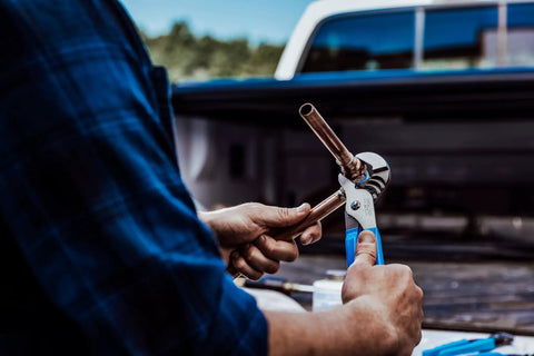 Person using Workhorse 4 Piece Pliers Set With Tongue and Groove, Diagonal Cutting, Long Nose and Slip Joint Pliers, high carbon steel, outdoor work.