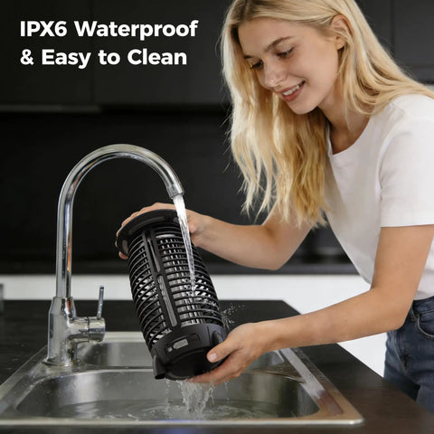 Woman rinsing Cordless 4-In-1 Bug Zapper For Outdoor Use under a kitchen faucet, showcasing IPX6 waterproof design.