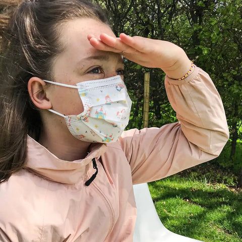 Girl wearing Kids Disposable Face Masks For Girls Aged 6 To 12, 10 Pack, Breathable Protective Masks With Fun Print Designs in garden
