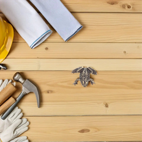 Tools and toad shaped brass cabinet drawer pulls for vintage style retro hardware renovation setup on wood surface