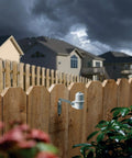 CPRSDBEX Wired Rain Sensor with mounting bracket on a wooden fence for sprinkler systems, cloudy sky background