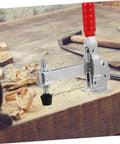 Side view of hand toggle clamp with red handle and rubber tip on woodworking bench. Two Pack Hand Toggle Clamps With Rubber Tips Quick Release Iron Fixed Toggle Clamps For Woodworking Jigs And Fixtures Durable Hold Down Clamps For Welding And Shop Projects.