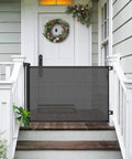 Retractable Baby Gate For Stairs And Doorways, 33 Inch Tall, Extends Up To 55 Inches Wide, on front porch with holiday decor