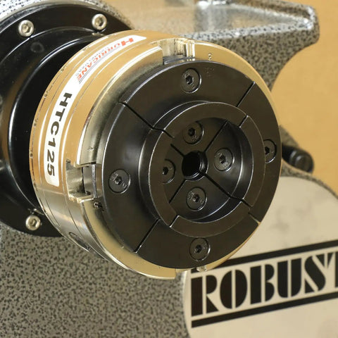 Close-up of HTC125 5 Inch Four Jaw Woodturning Chuck Kit on lathe with metallic finish and visible branding.