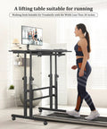 Woman using rolling standing desk on wheels with height adjustment, watching monitor while on a treadmill in home office