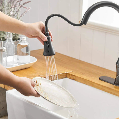 Oil Rubbed Bronze Kitchen Faucet With Pull Out Sprayer, Three Spray Modes, Single Handle in use over sink washing a dish