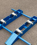 Beefy Heavy Duty Cable Roller Guide Wheel With Wide Flanges And Hollow Center Solid Steel Construction Smooth Machined Surface For Low Friction Cable Control Built For Workshops Construction Sites And 3 To 5 Ton Capacity on blue frame