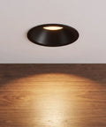 Operitacx Black Metal MR16 Downlight Housing, Fits 1.57" Cut-Out, 3.3" OD, installed in ceiling with warm spotlight illumination.