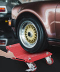 Heavy Duty Carbon Steel Tire Wheel Dollies Set Of 4 Car Movers With Anti Skid Plate And 360 Degree Rotating Wheels 16 By 13 Inches Red Each Supports Up To 1500 Lbs placed under a car wheel.