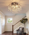 Small Crystal Chandelier Flush Mount Ceiling Light Three Light Modern Sleek Chrome Iron Raindrop Fixture illuminating an entryway.