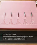Linocut Cutter Kit 6 Pack With 5 Interchangeable Blades displayed on soft pink carving block.
