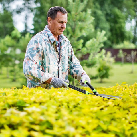Man using Heavy Duty Telescoping Hedge Shears 23 To 30 Inches With 20 Degree Angled Head Rust Proof Carbon Steel Blades