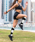 High Performance Unisex Athletic Compression Socks Featuring Graded Ankle Support Breathable Moisture Wicking Fabric Black White Piano Plate Grid Design in action during running.