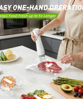 Handheld vacuum sealer, white cordless, sealing raw steak in a vacuum bag on kitchen counter