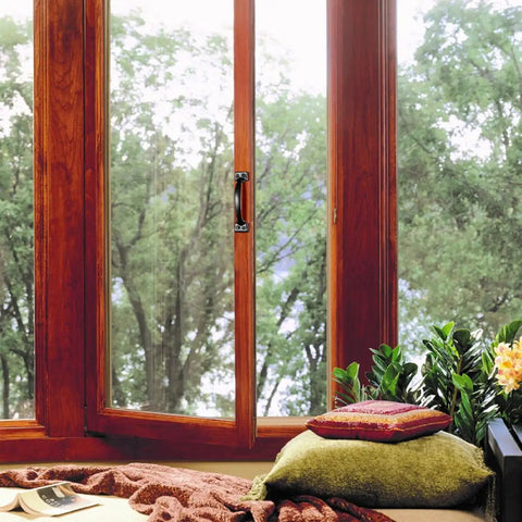 Cozy window nook with pillows and a view of trees outside.
