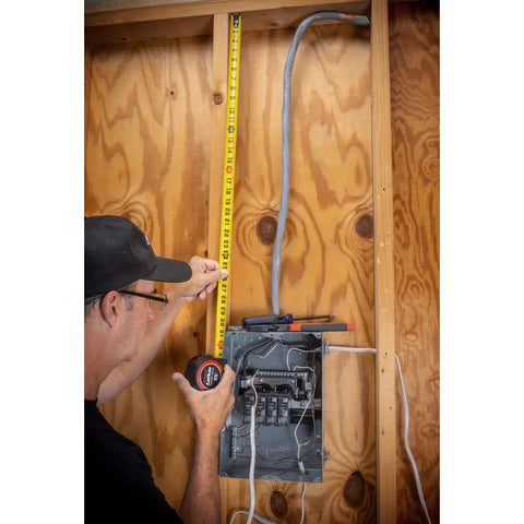 Person using 1-3/16 X 25 Foot Command Control Engineers Tape Measure Yellow Clad With Anti Pinch Lock Button on wall