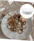 Autonomic Electric Rotating Display Stand For Jewelry Watches And Collectibles With Adjustable Speed smooth turntable showcasing gold jewelry on a plate.