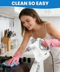 No Sweat Handheld Steam Cleaner For Home being used on kitchen stove by woman wearing pink gloves, portable and fast heating.