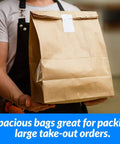Person holding Heavy Duty Brown Kraft Paper Bags 125 Count Large 12 By 7 By 17 Inches 70 Pound Basis Weight Bulk Pack